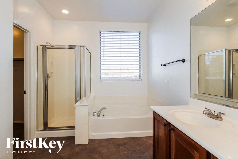 A white bathroom with a walk in shower and a bathtub.