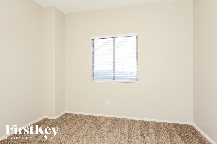 A room with a window and a carpet on the floor.