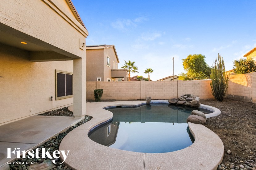 A small pool in a backyard with a Firstkey Homes logo.