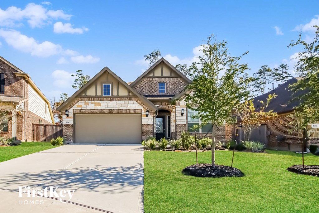 A house with a garage and a driveway in front of it.