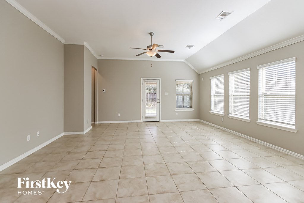A spacious room with a ceiling fan and tiled flooring.