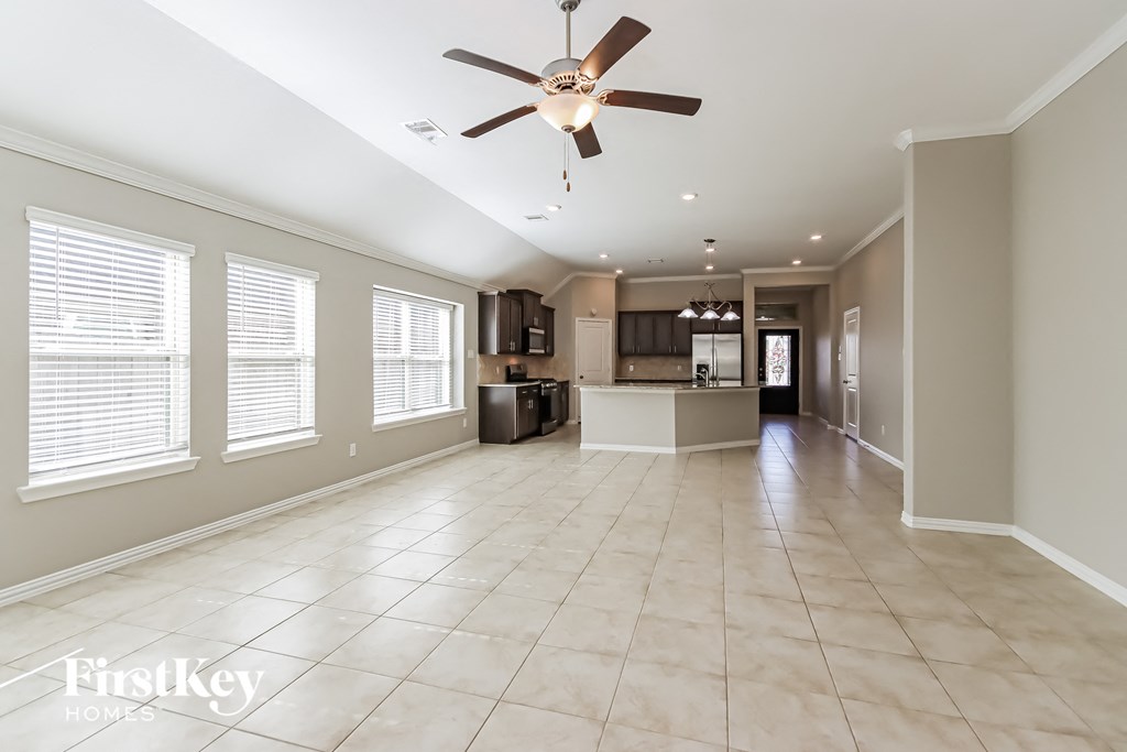 A spacious room with a ceiling fan and tiled flooring.