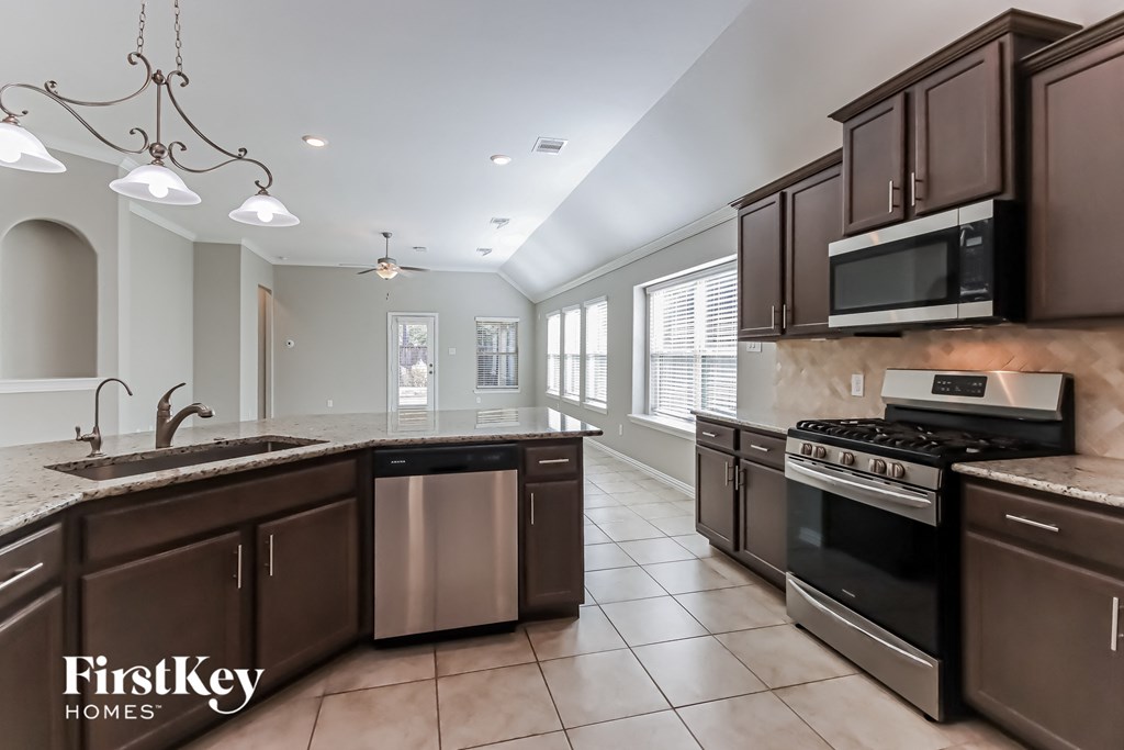 A kitchen with brown cabinets and a stainless steel dishwasher.