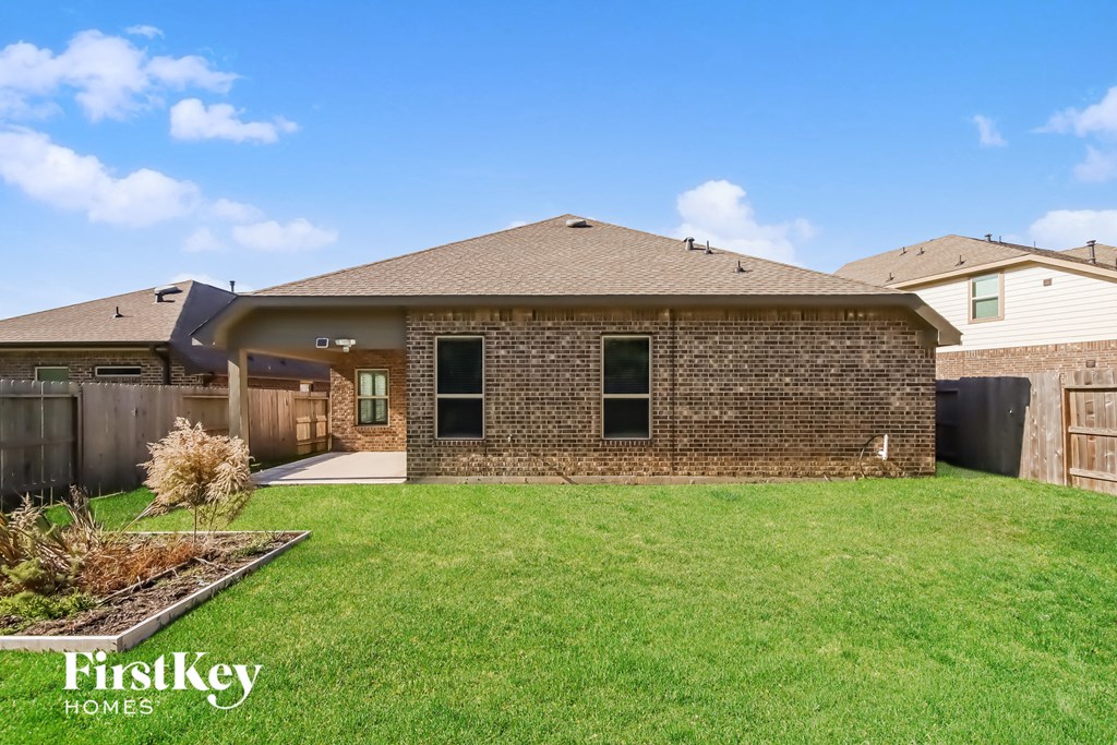 A house with a brown brick exterior and a well-maintained lawn.