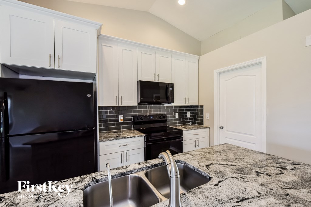 a kitchen with black appliances and granite counter tops