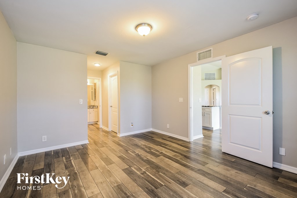a living room with a hard wood floor and a white door