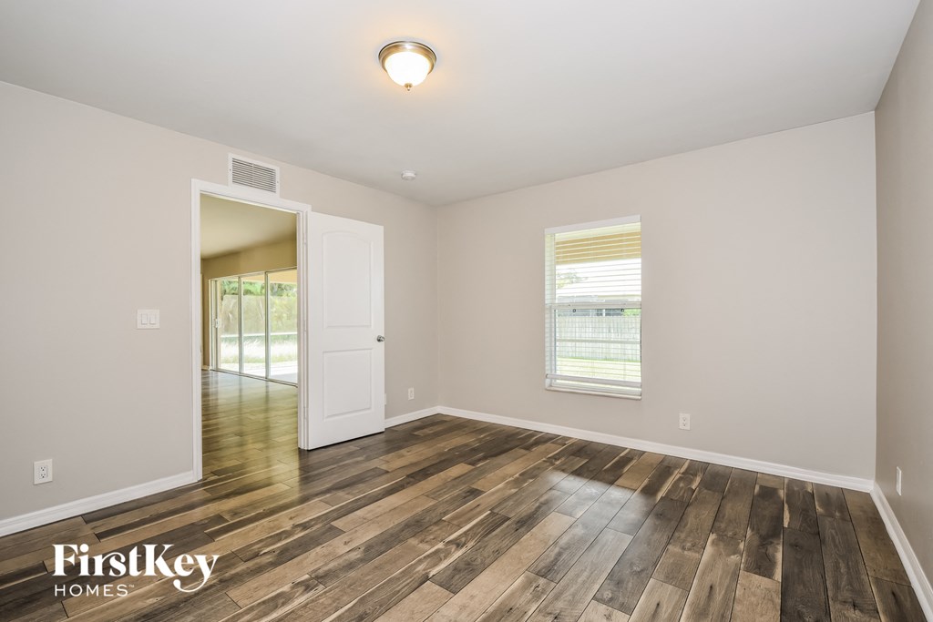 the living room and dining room of a house with wood floors and a white door