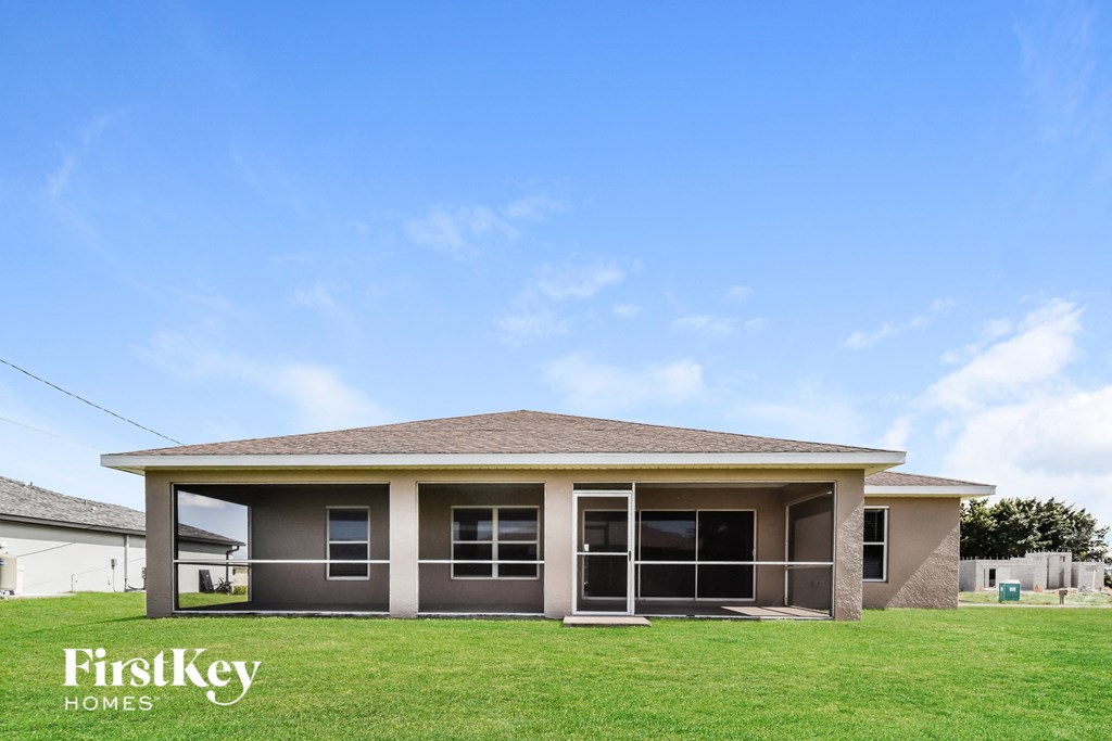 a small house with a lawn and a blue sky