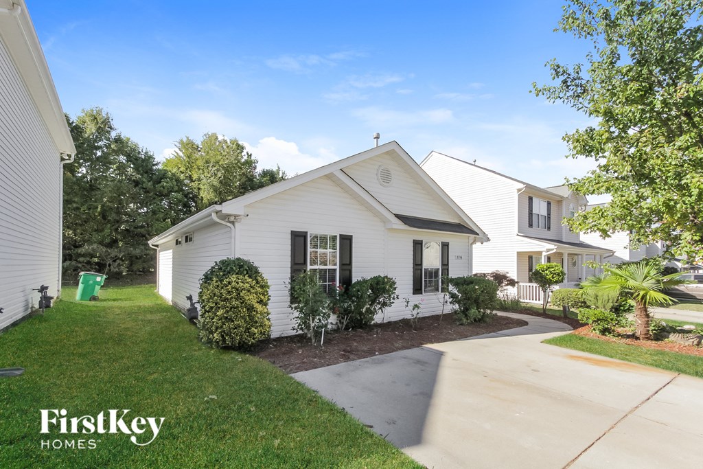 a white house with a sidewalk in front of it