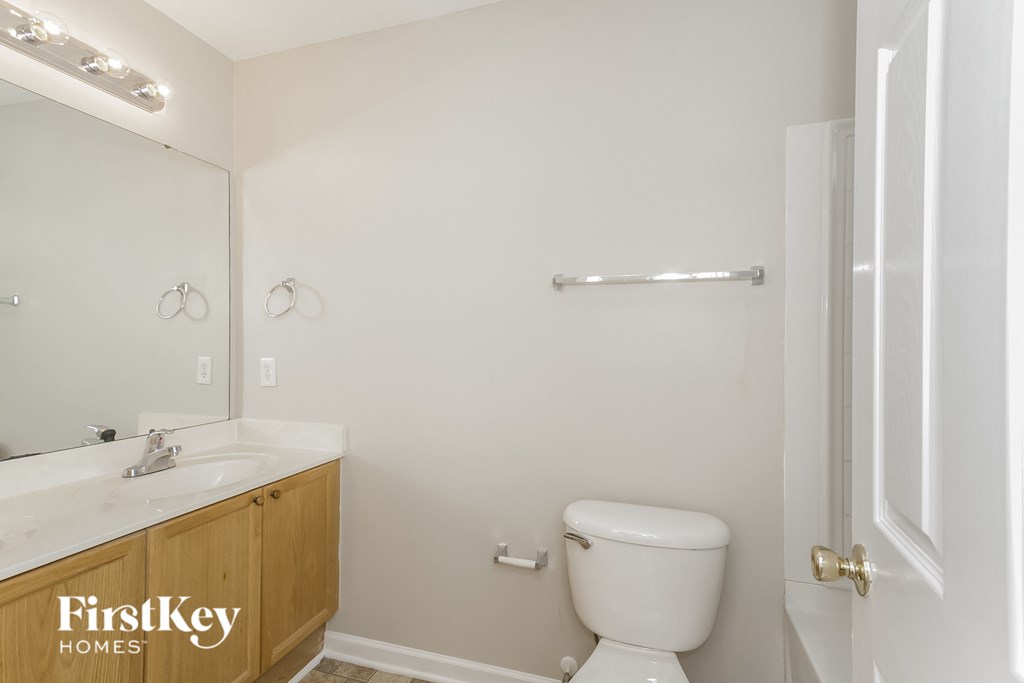 a bathroom with a toilet and a sink and a mirror