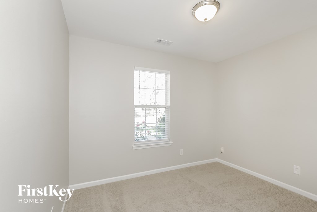 a bedroom with white walls and a window