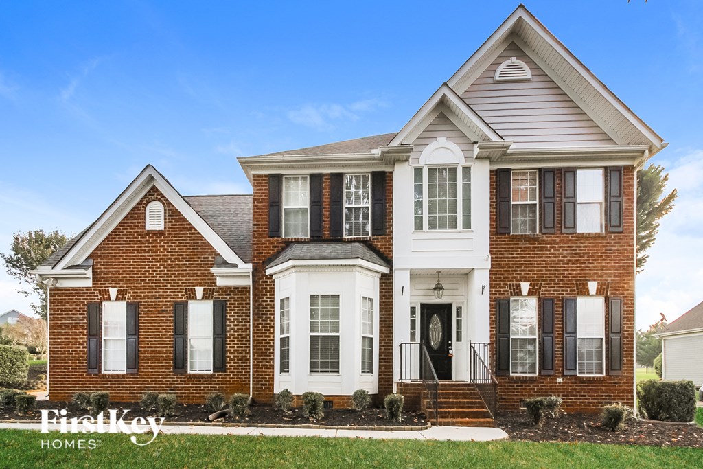 a brick house with black shutters and a white front door