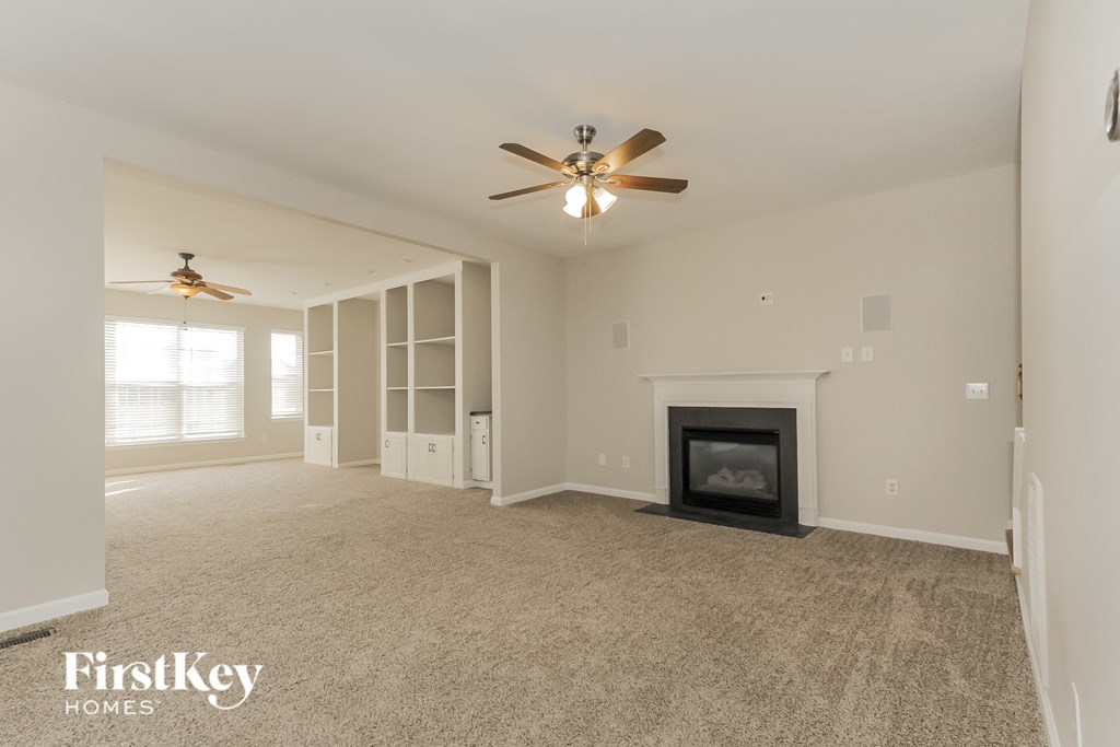 a living room with a fireplace and a ceiling fan