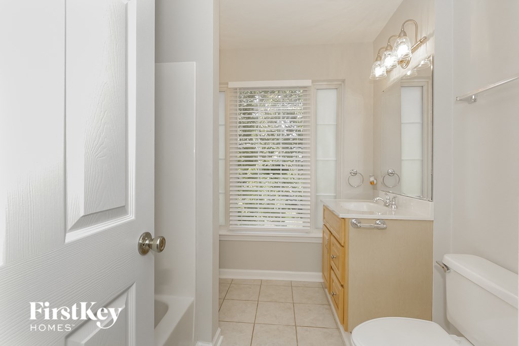 a bathroom with a toilet and a sink and a window