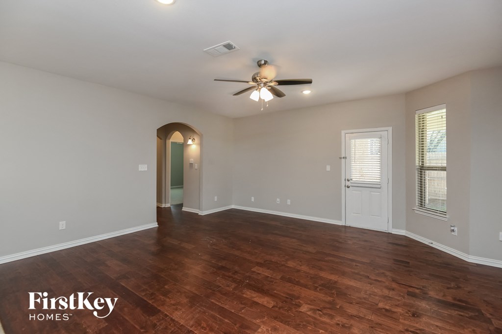 the living room of an empty house with a ceiling fan