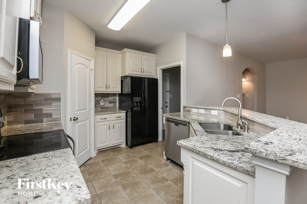 a kitchen with granite counter tops and white cabinets