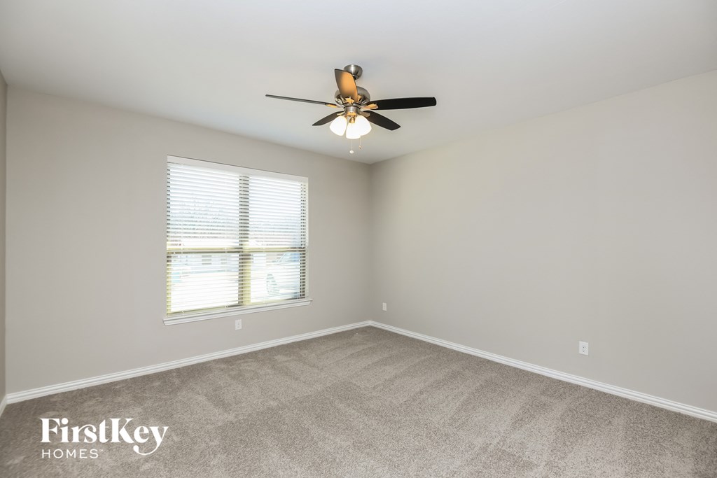 a bedroom with a ceiling fan and a window