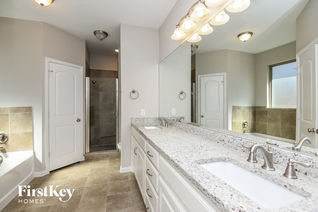 a white bathroom with two sinks and a shower