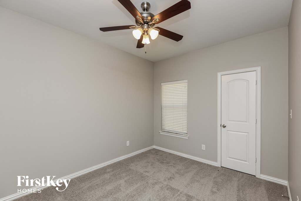 a bedroom with a ceiling fan and a white door