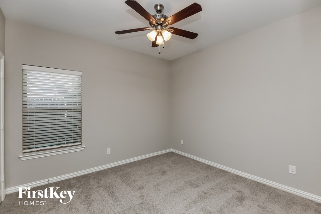 a bedroom with a ceiling fan and a window