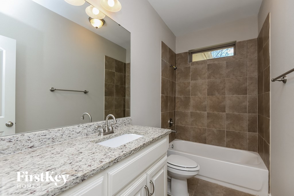 a bathroom with a tub and a sink and a toilet