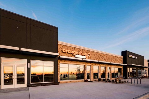 The exterior of a Fangshoe store with a clear sky in the background.