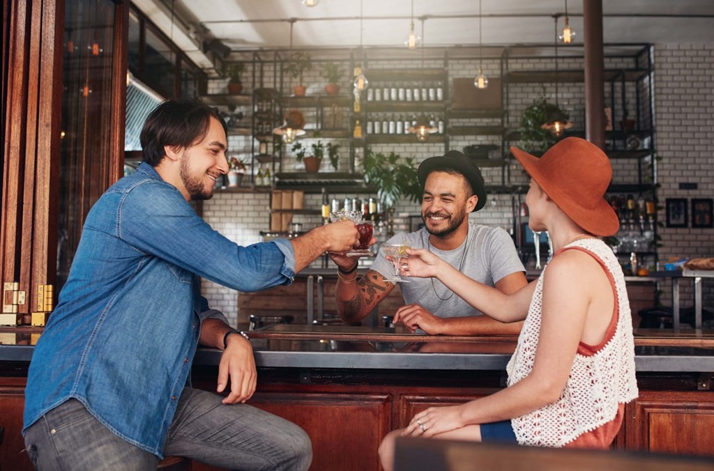 three people sitting at a bar