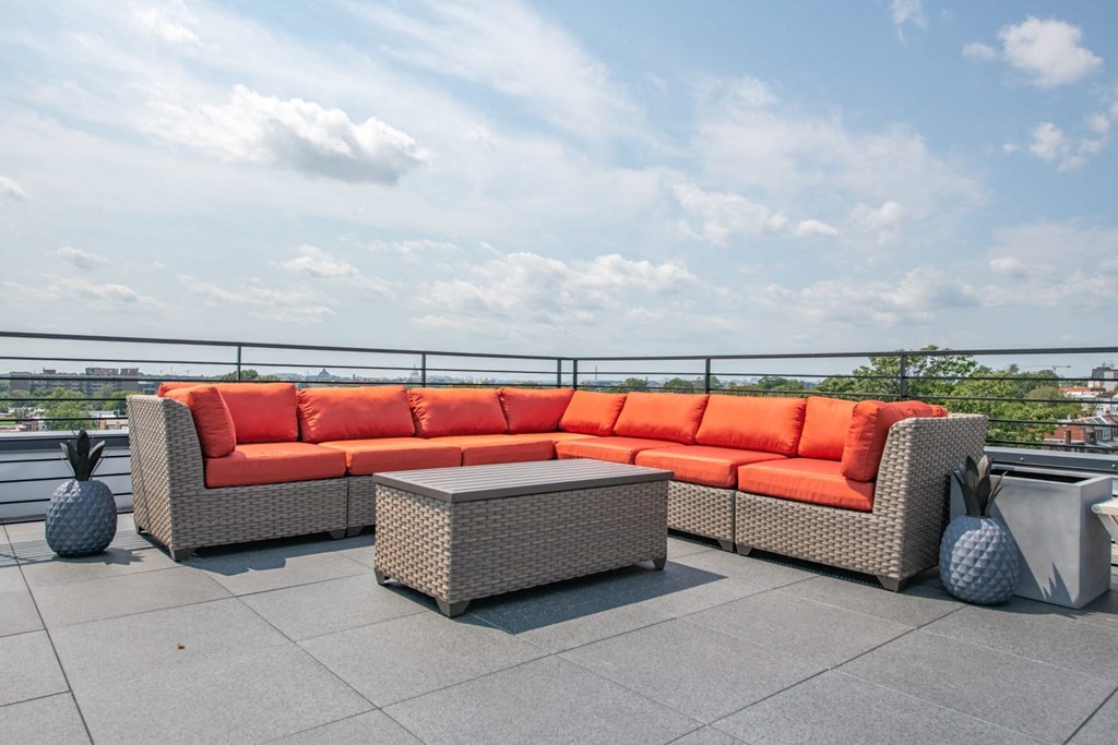 a terrace with couches and a table on a roof