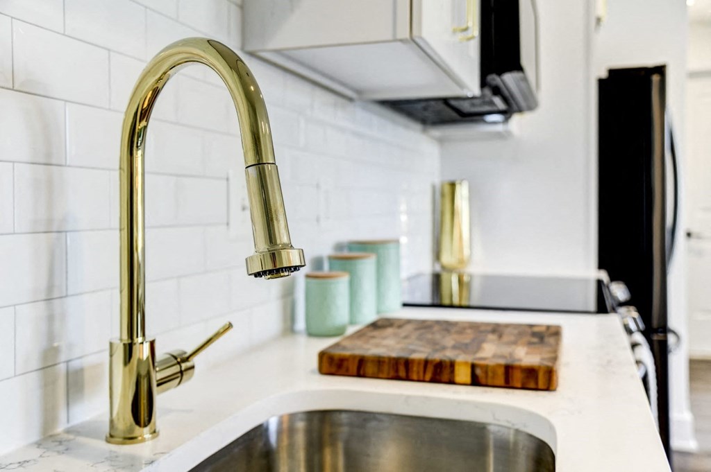 a kitchen sink with a faucet and a cutting board