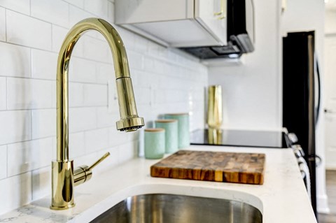 a kitchen sink with a faucet and a cutting board
