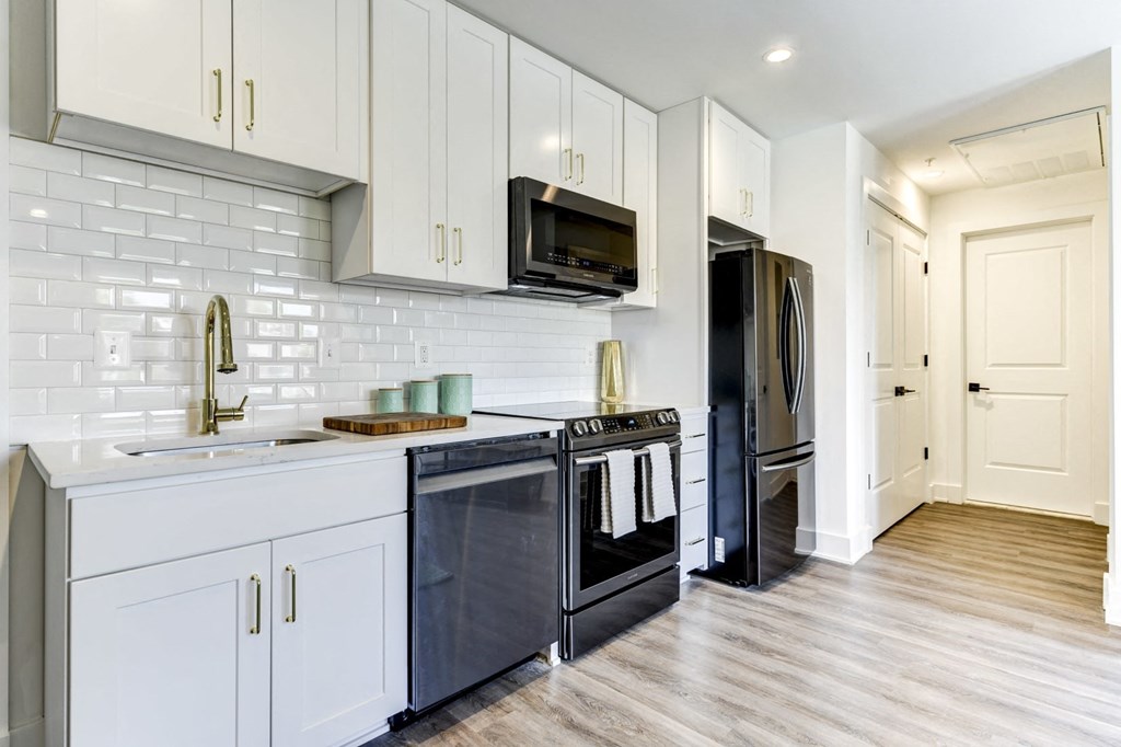 a white kitchen with stainless steel appliances and white cabinets