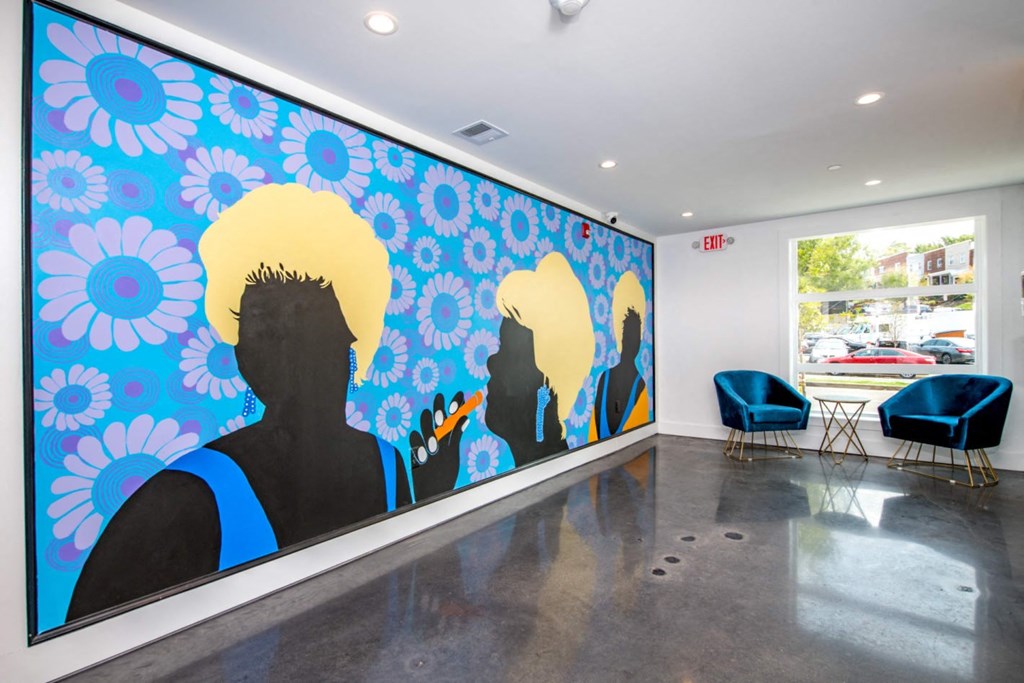 a mural in the lobby of a building with blue chairs