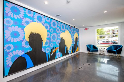 a mural in the lobby of a building with blue chairs