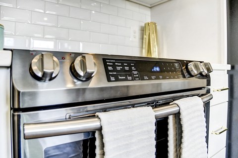 a kitchen with a stainless steel stove and oven with towels hanging on it