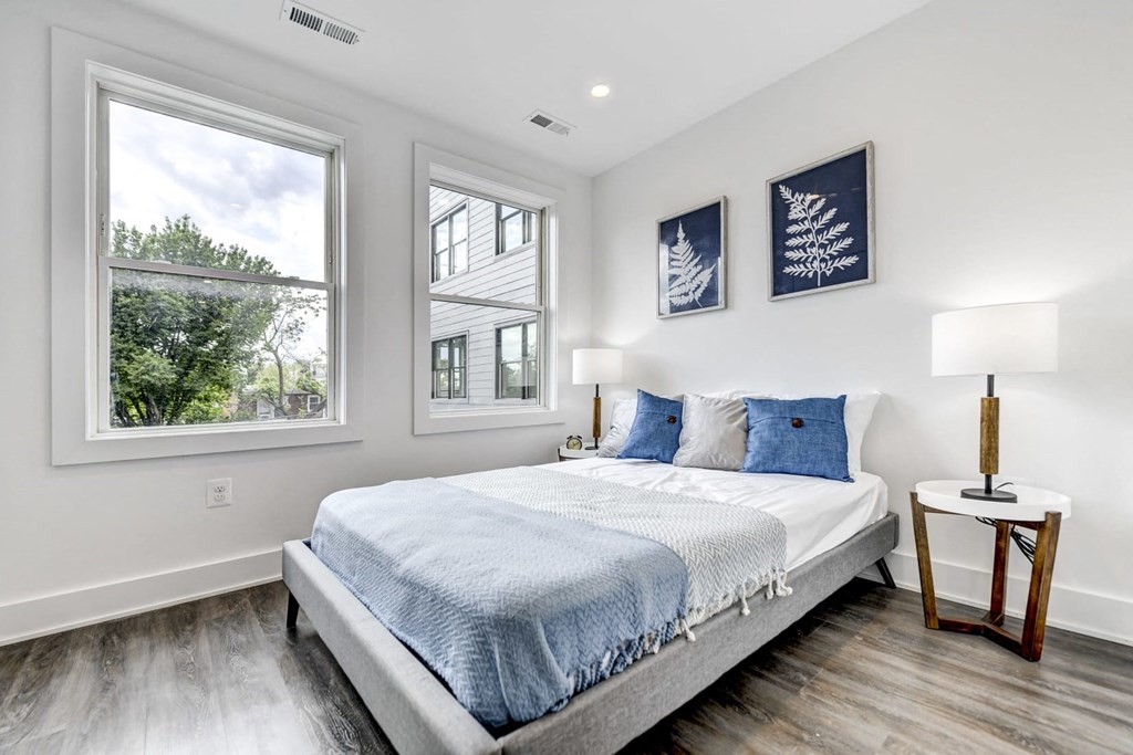 a bedroom with a bed and three windows