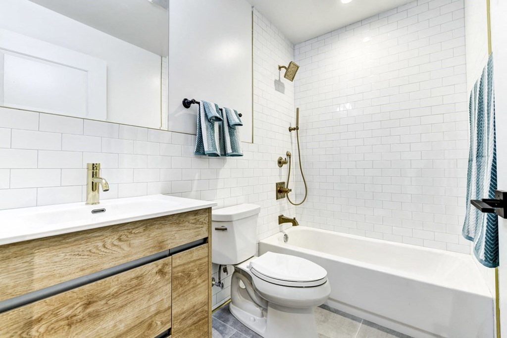 a bathroom with a toilet and a tub and a sink