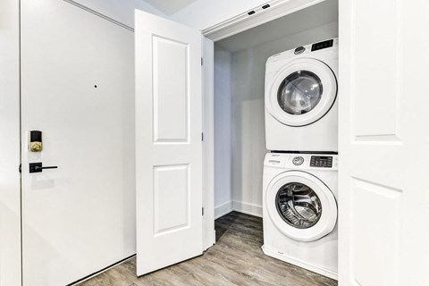 a white washer and dryer in a room with a door