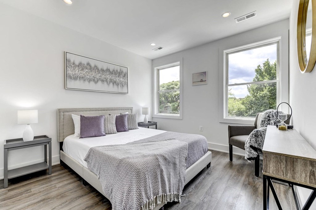 a bedroom with a bed and two windows