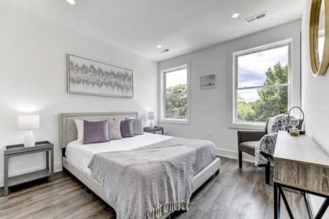 a bedroom with a bed and two windows