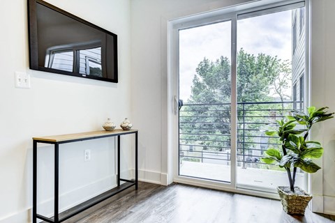 a living room with a door to a balcony and a television