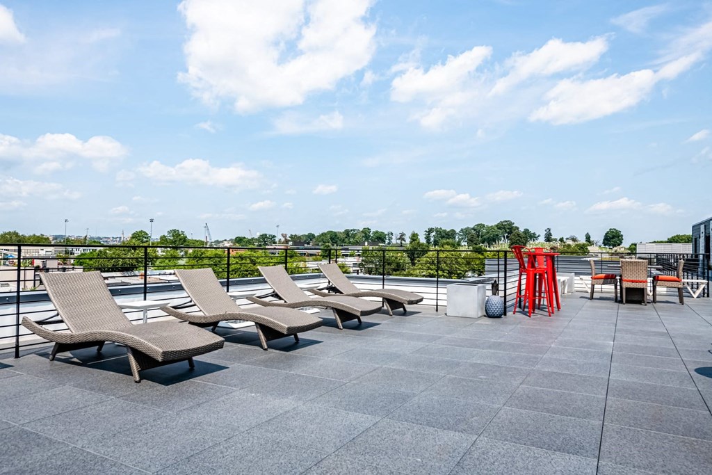 a row of lounge chairs on the rooftop of a building
