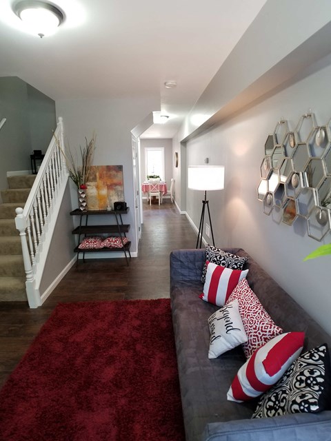 a living room with a couch and a red rug