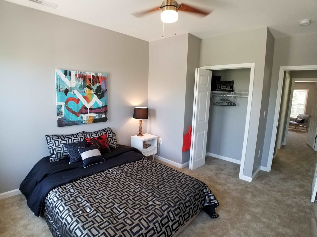 a bedroom with a bed and a ceiling fan