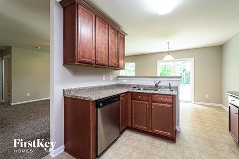 A kitchen with wooden cabinets and a granite countertop.
