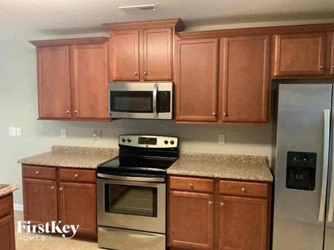 A kitchen with wooden cabinets and a stove top oven.