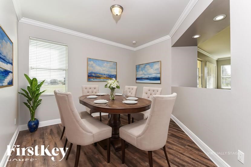 A dining room with a wooden table and chairs.