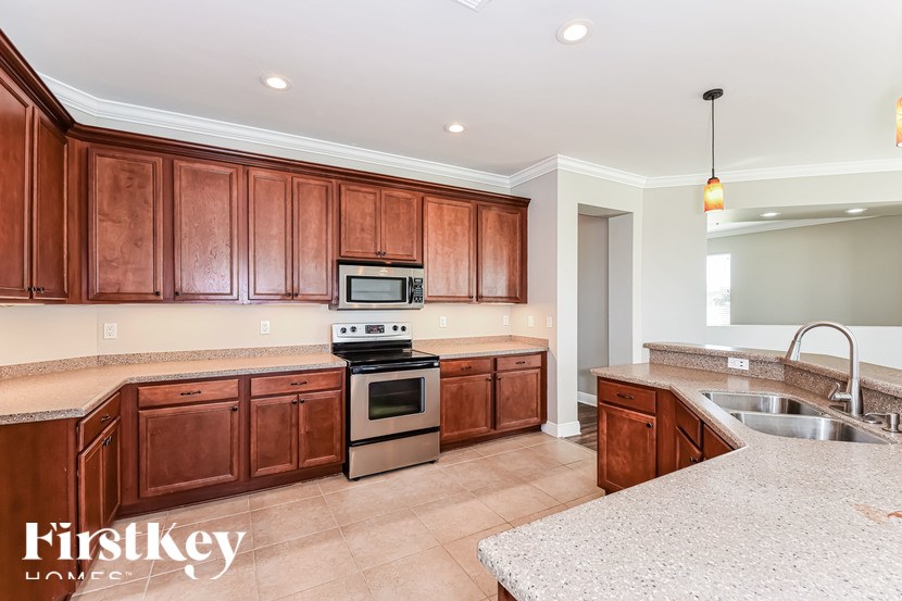 A kitchen with wooden cabinets and a stove top oven.