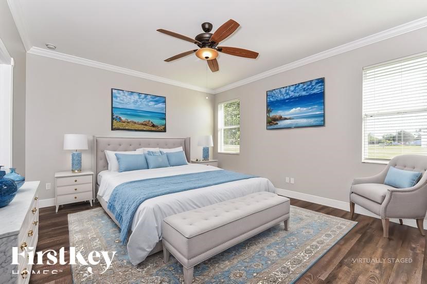 A bedroom with a bed, a chair, and two pictures on the wall.