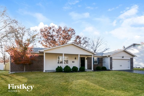 a white and brick house with a grassy yard