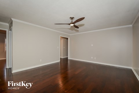 a living room with wood floors and a ceiling fan